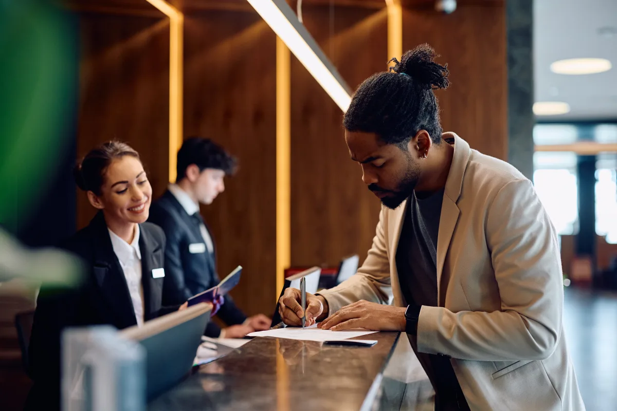 A guest completing registration at a hotel front desk